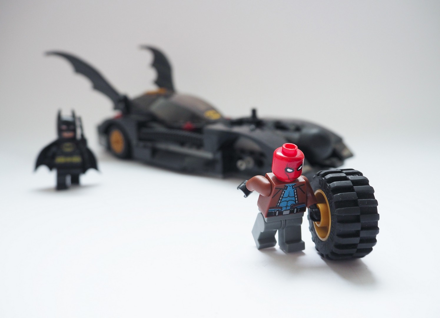 red_hood_stealing_batmobile_tyre.jpg
