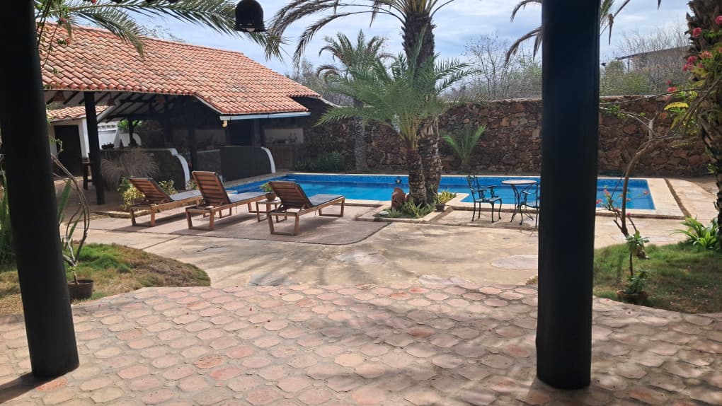 Jardín y piscina de Posada Yaque Sol al atardecer — El Yaque, Isla de Margarita