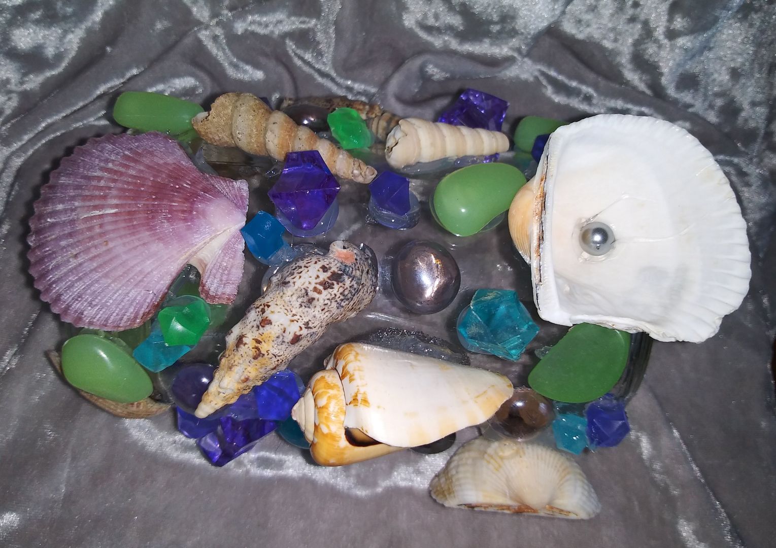 Aquarium ornament from glass and plastic jars with sea shells acrylic gems faux pearls and glow in the dark accents. Some even float!