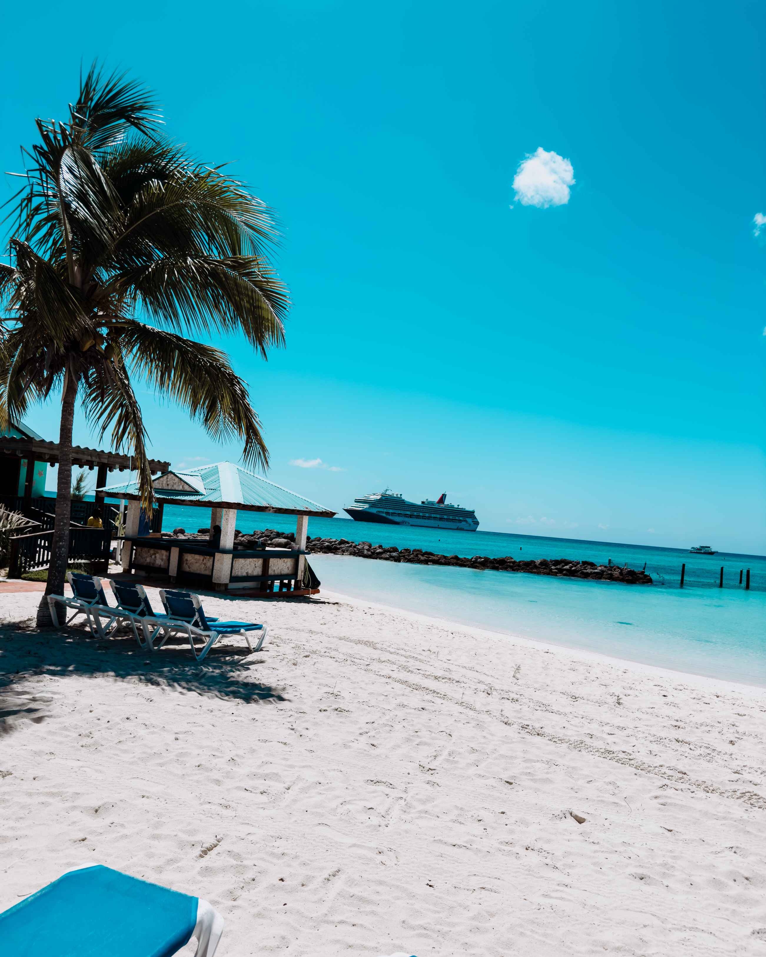 Princess Cays Cruise Port - Two Lounge Chairs on a Beach with a Cruise Ship in the Background - Vertical.jpg