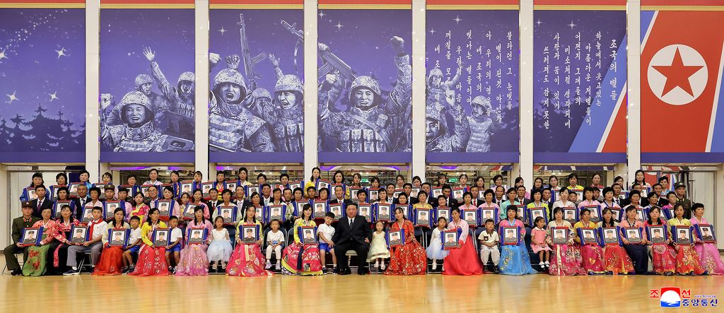 RespectedComrade Kim Jong Un meets bereaved families of martyrs who performed distinguished feats in overseas military operations and has photo session with them - Image 4
