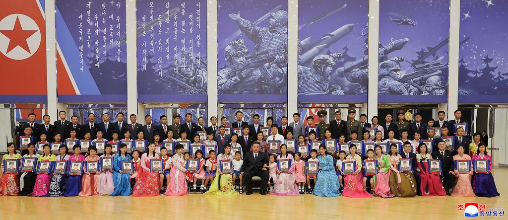 RespectedComrade Kim Jong Un meets bereaved families of martyrs who performed distinguished feats in overseas military operations and has photo session with them - Image 5
