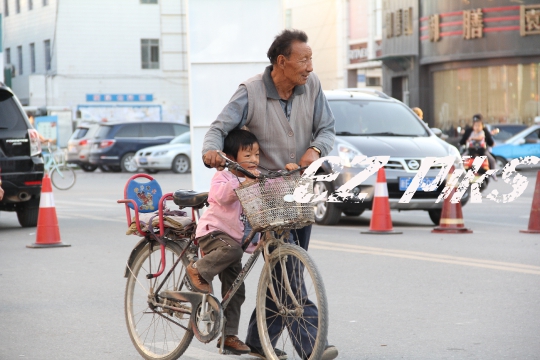 Xinjiang man pushing a bike 