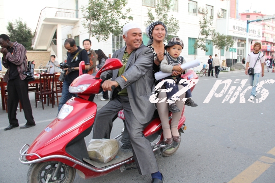 Uighur family on a scooter 