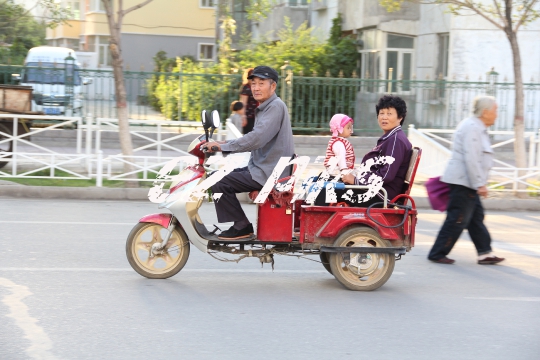 Xinjiang family on a scooter