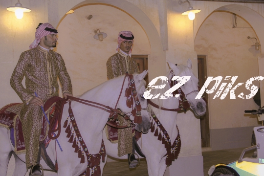 Policemen on horses getting ready for routine patrol in traditional Souq Waqif market.