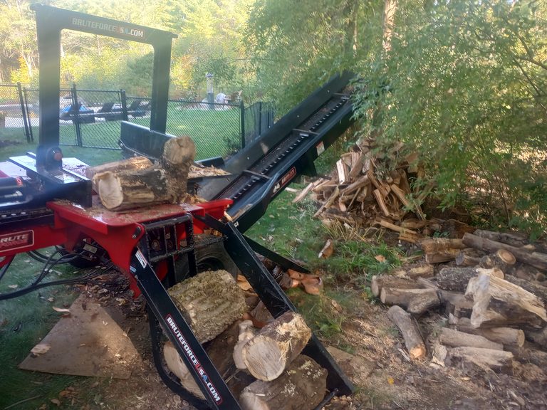 Mobile log splitter processing firewood at a residential jobsite