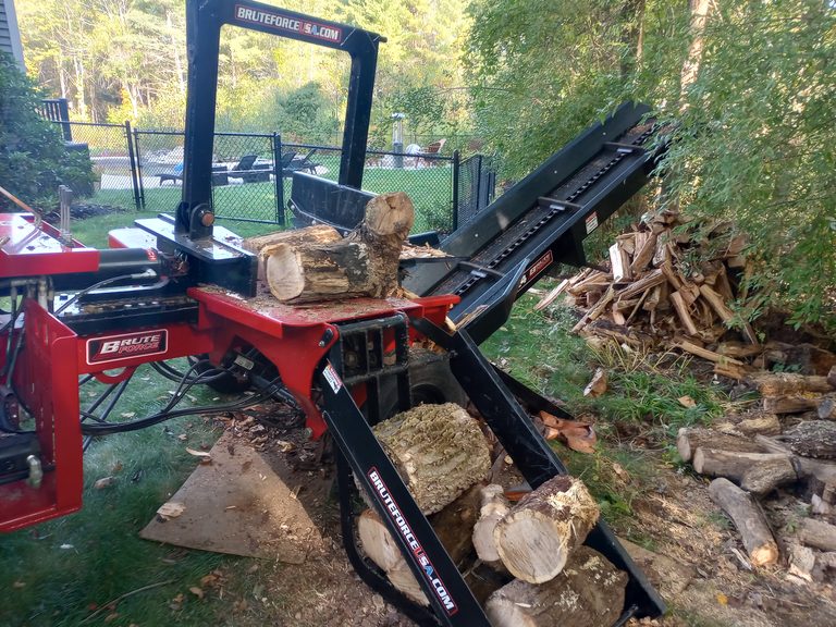 Log splitter set up beside a pile of rounds ready for processing