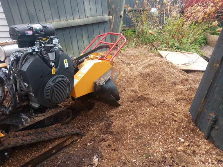 Stump grinder and fresh grindings after tree-removal add-on work
