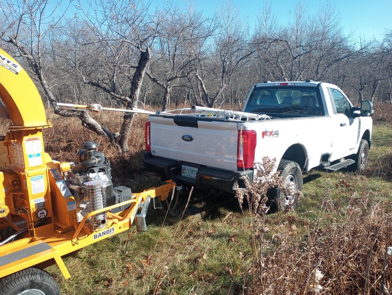 Northeast Forest truck and wood chipper at a fruit orchard during dormant-season pruning work