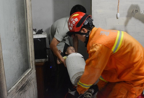 Firefighters transport a 3-year-old boy stuck in the cylinder of a washing machine before carrying out rescue operations in Yongjia county of Wenzhou