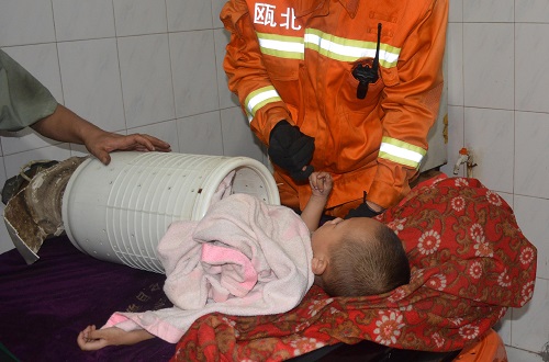 A 3-year-old boy, stuck in the cylinder of a washing machine, hooks the pinky of a firefighter during a rescue operation in Yongjia county of Wenzhou