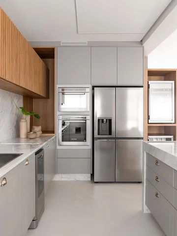 Uma linda cozinha com marcenaria cinza, detalhes amadeirados e bancada marmoriza