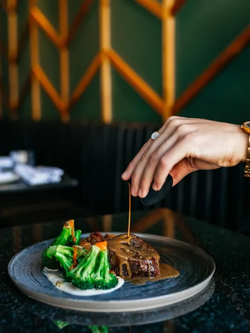 Our Mati Signature Tenderloin, finished with demi-glace, paired with broccoli an