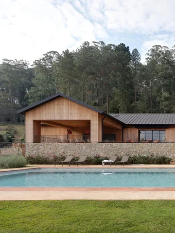 A whimsical vision of a barn-style house in a sloped terrain near a lake.

LOC C