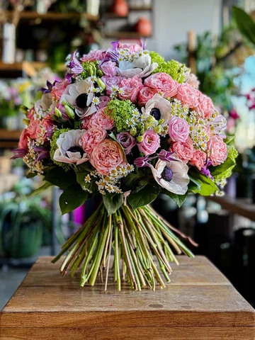 Full of life and color! This cheerful bouquet of pink roses, anemones, green vib