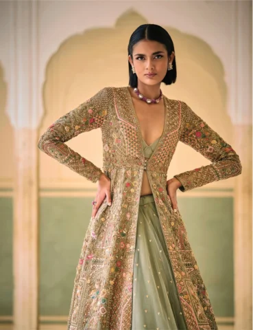 An elegant sage-green raw silk jacket, hand-embroidered with intricate details. 
