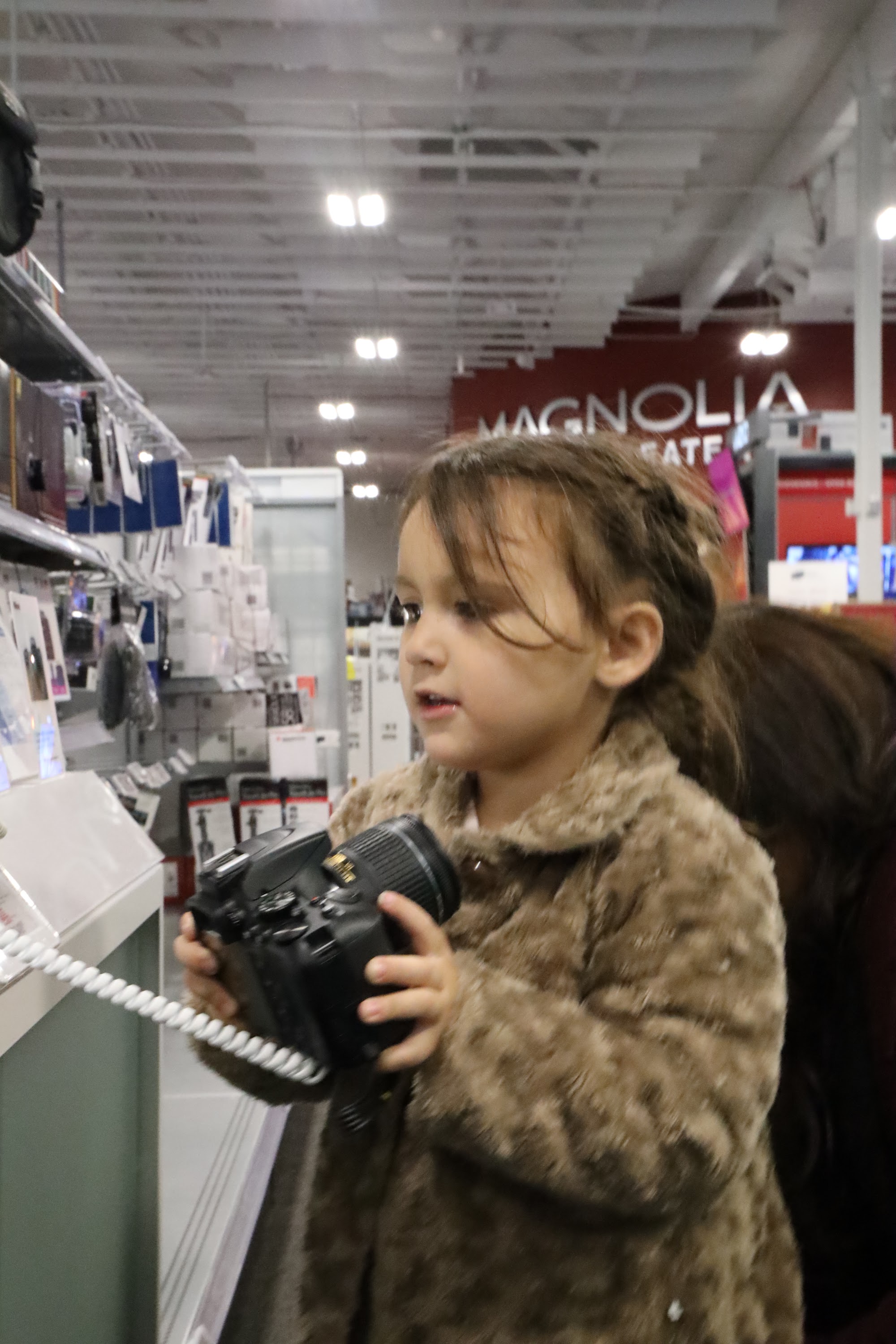 Young Girl Holding Camera in Store