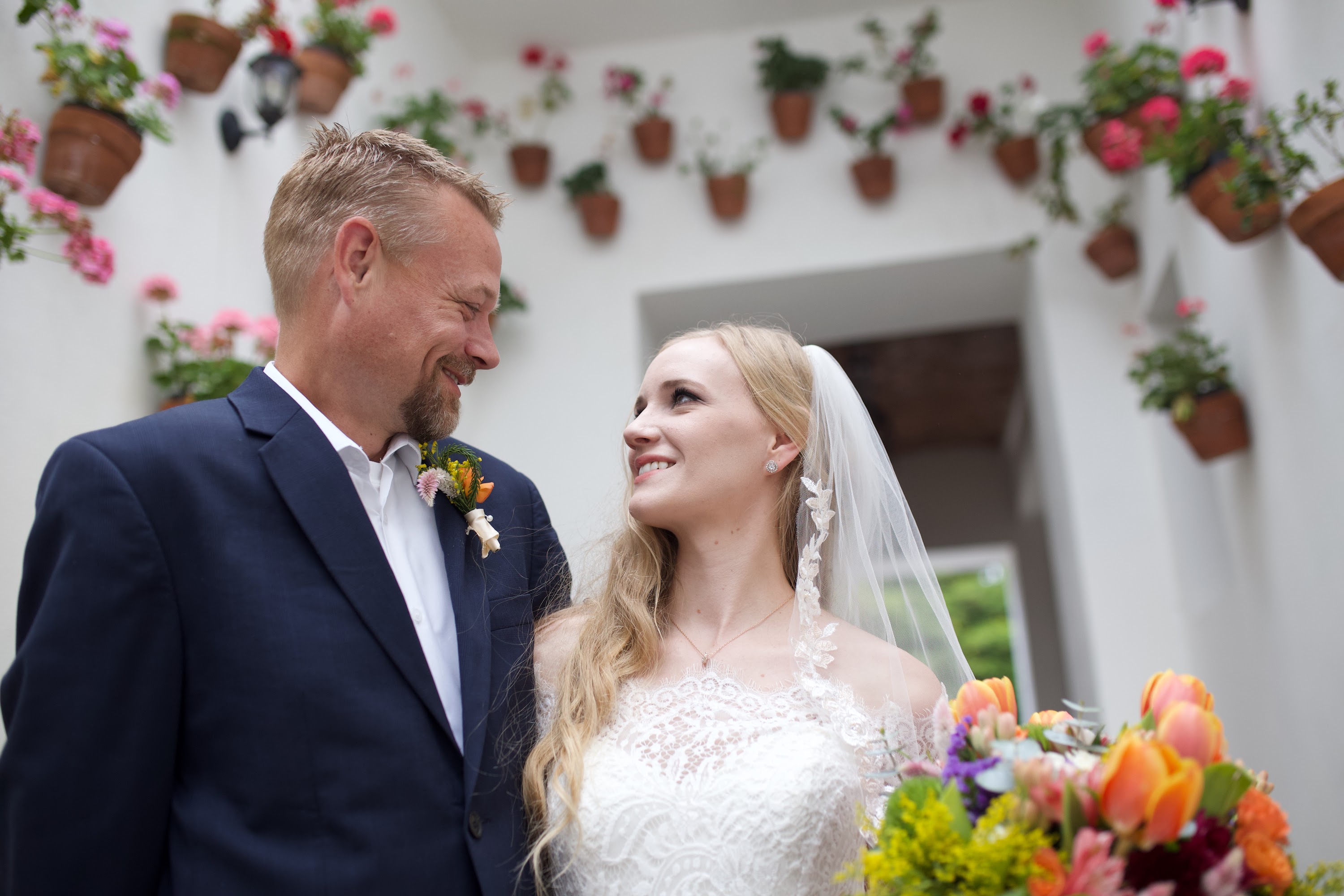 Bride and Groom Sharing a Moment Amidst Flower-Adorned Walls