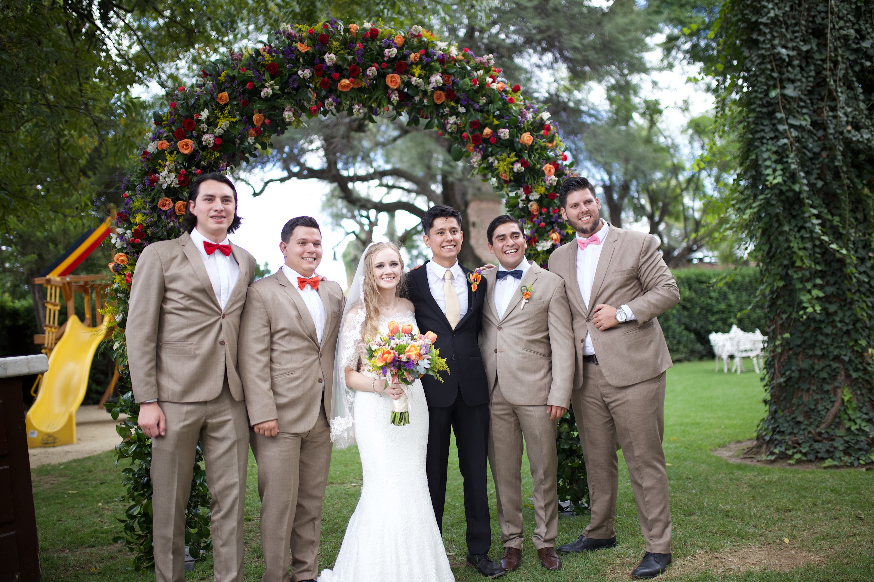 Bride and Groom with Groomsmen Under Floral Arch