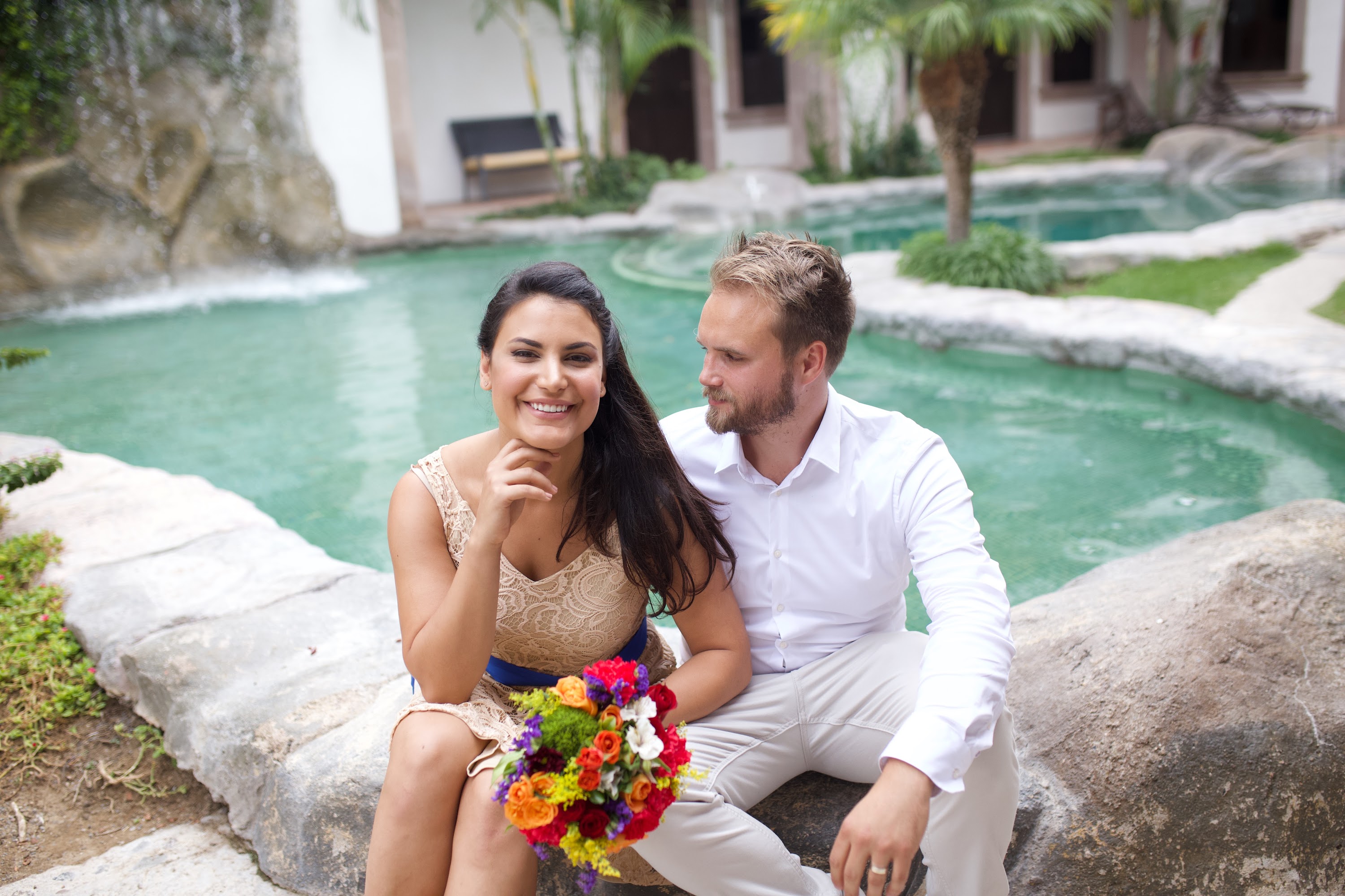 Couple Sitting by Water Feature with Bouquet