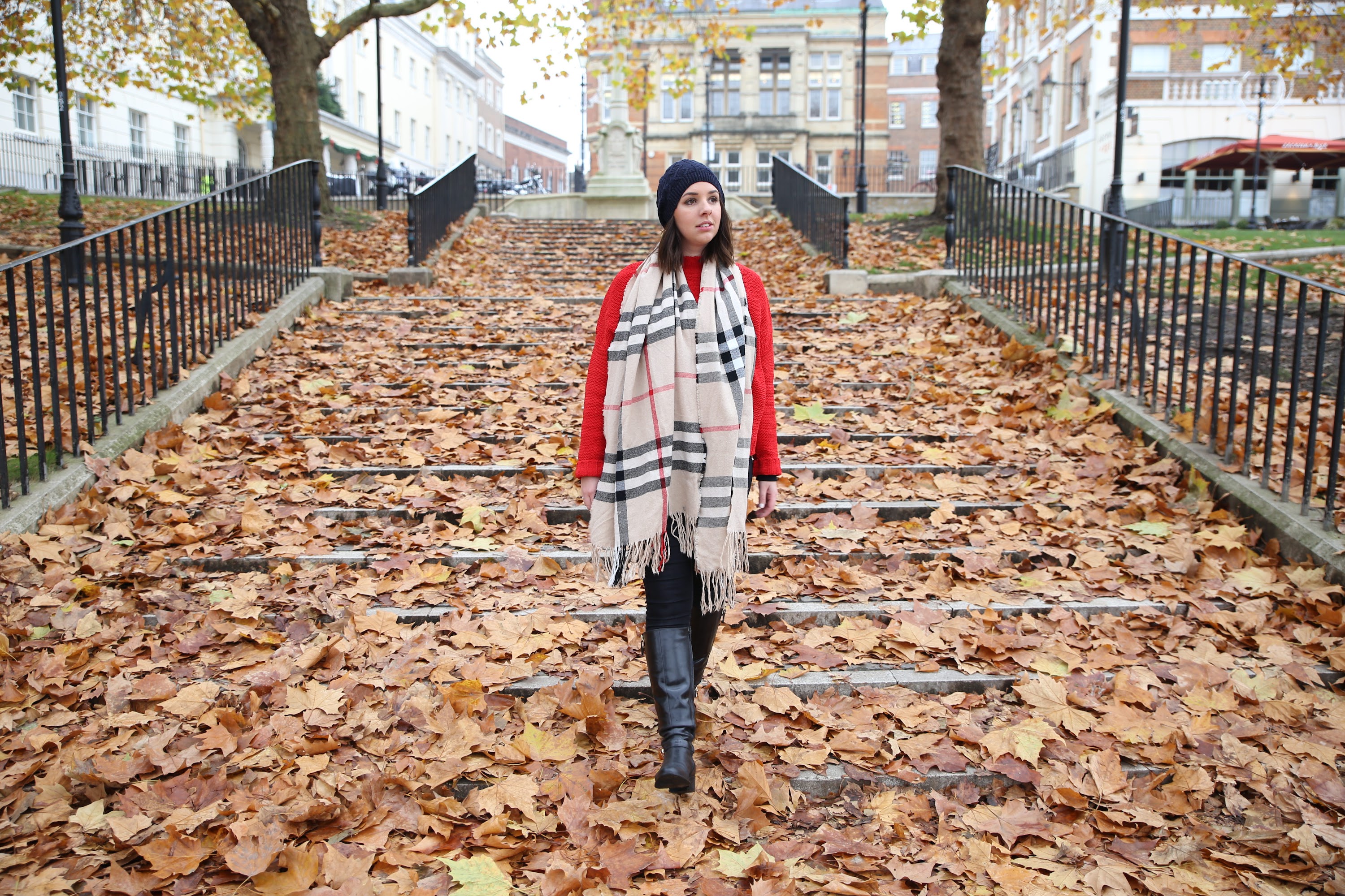 Woman in Boho Wrap and Pom-Pom Beanie Against Pink Wall