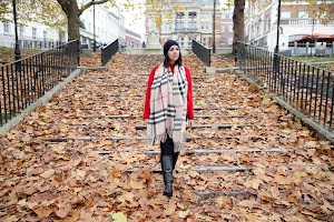 Woman in Boho Wrap and Pom-Pom Beanie Against Pink Wall