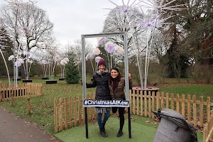 Two women posing in a photo frame at Christmas at Kew