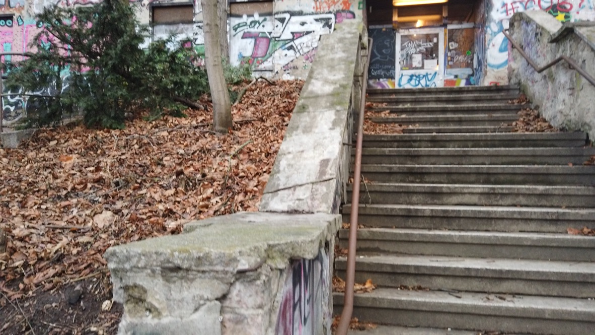 Graffiti-covered concrete stairs leading to an underground entrance