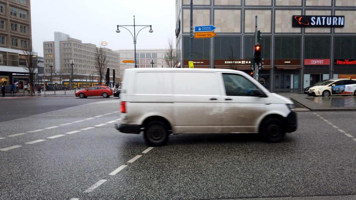 White van in motion at city intersection