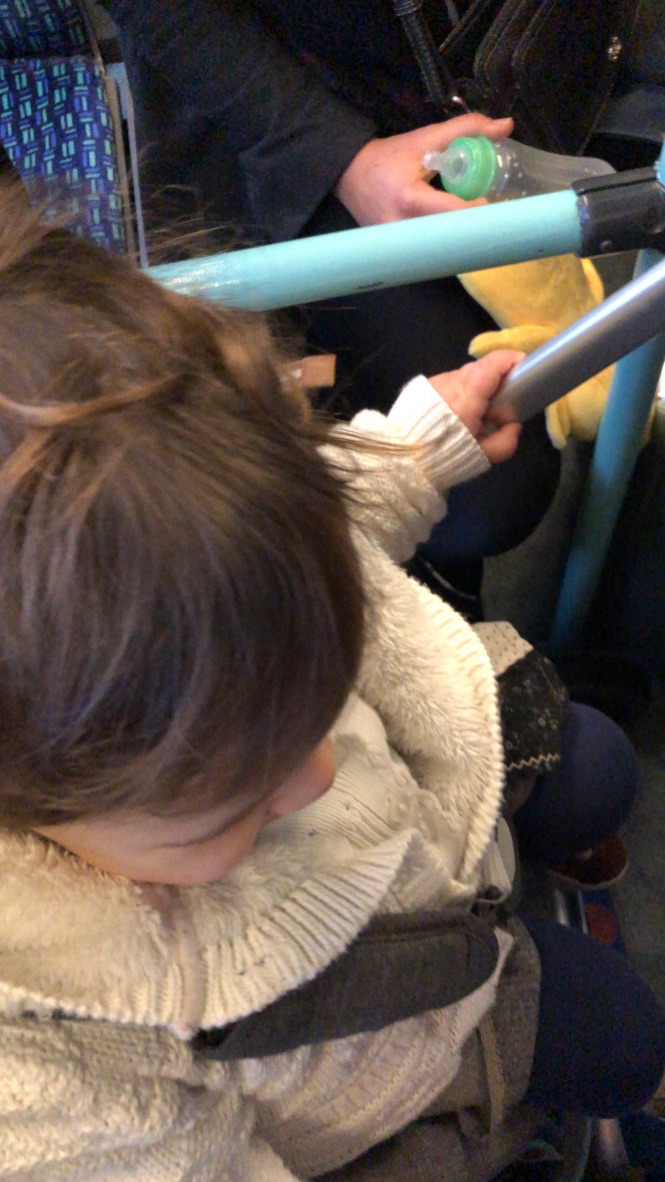 Child Holding Rail on Public Transport