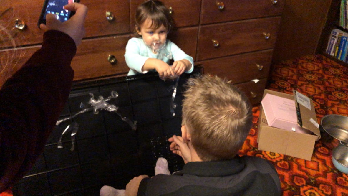 Child Playing with Bubbles Near a Dresser