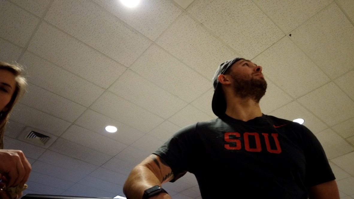 Man in SOU T-Shirt Looking Up at Ceiling