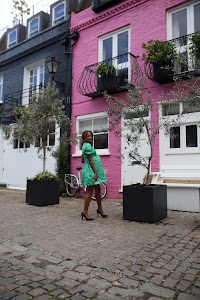 Woman in Green Floral Dress Walking on London Sidewalk