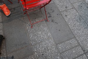 Red Chair and Orange Sneaker on Terrazzo Pavement