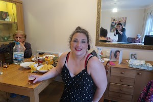 Woman Smiling at Dining Table with Family