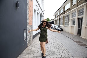Woman in Green Dress Dancing on Cobblestone Alley
