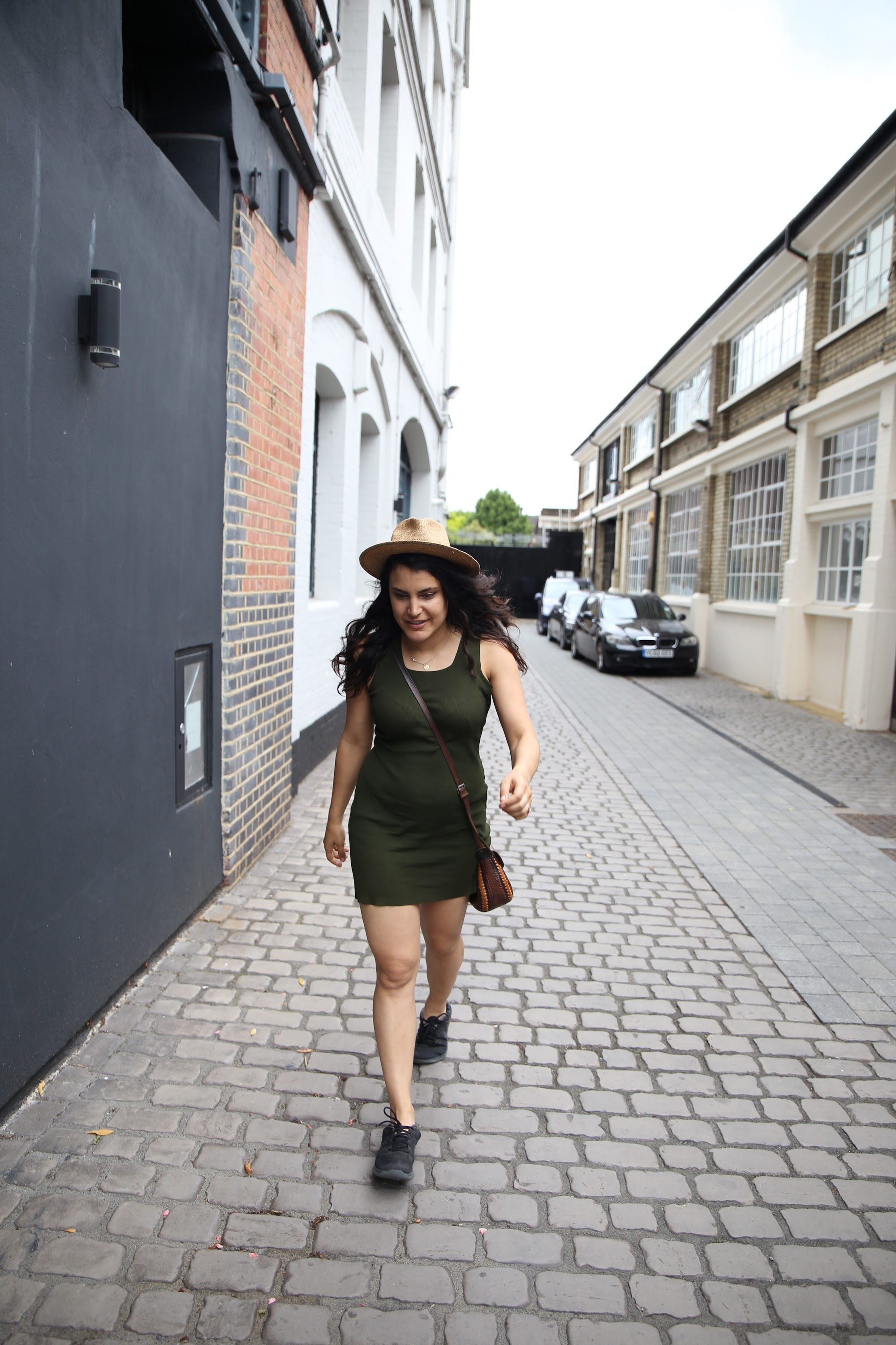 Woman Walking Down Cobblestone Alley in Green Dress
