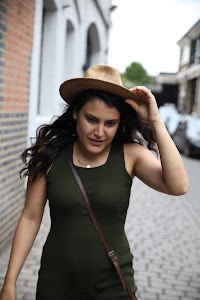Woman Adjusting Straw Hat on Cobblestone Street