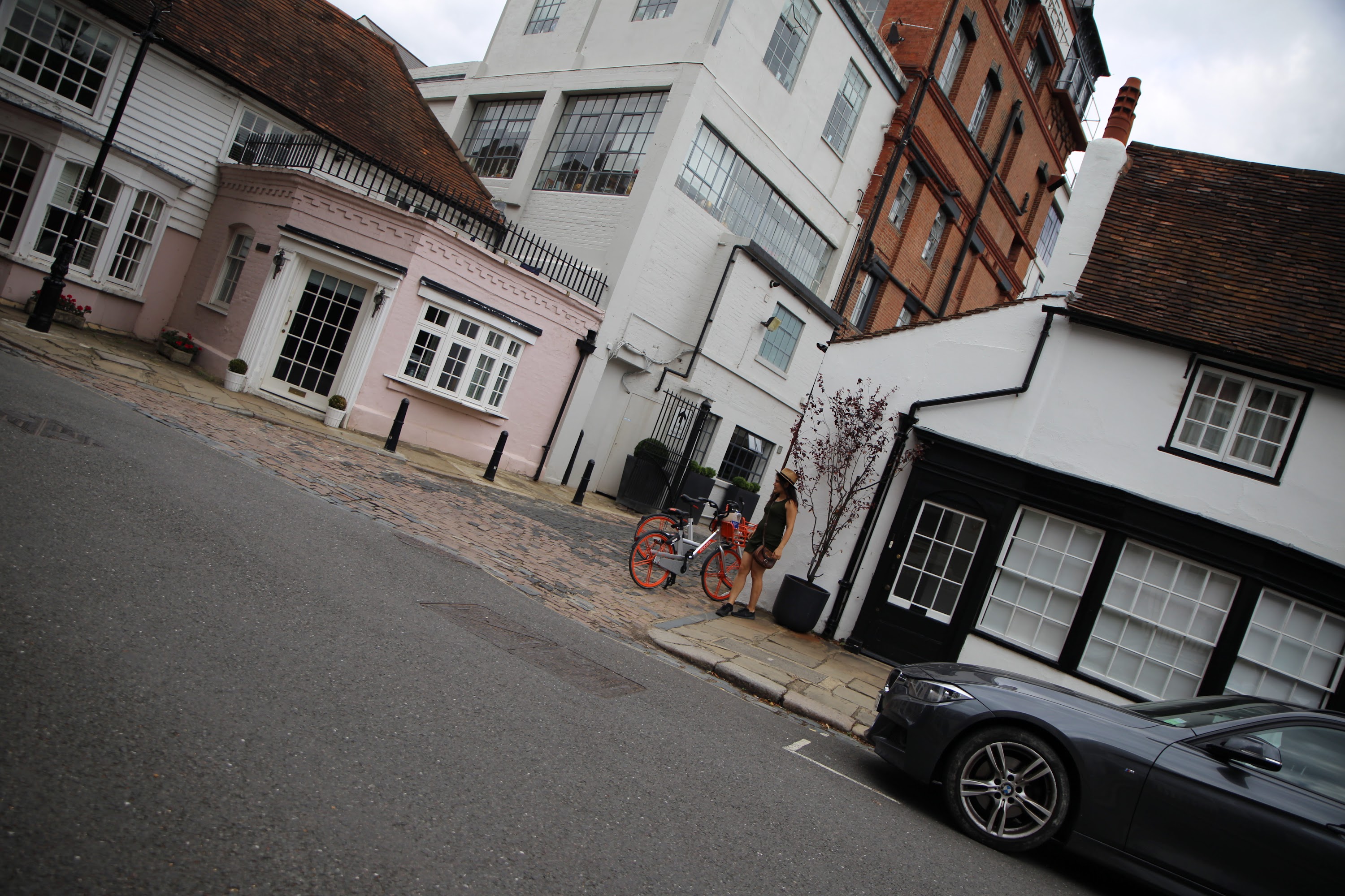 Person with Red Bicycle on Cobblestone Street