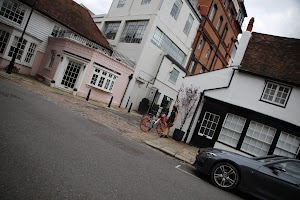 Person with Red Bicycle on Cobblestone Street