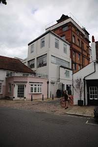 Woman with Red Bicycle in Front of Studios Building