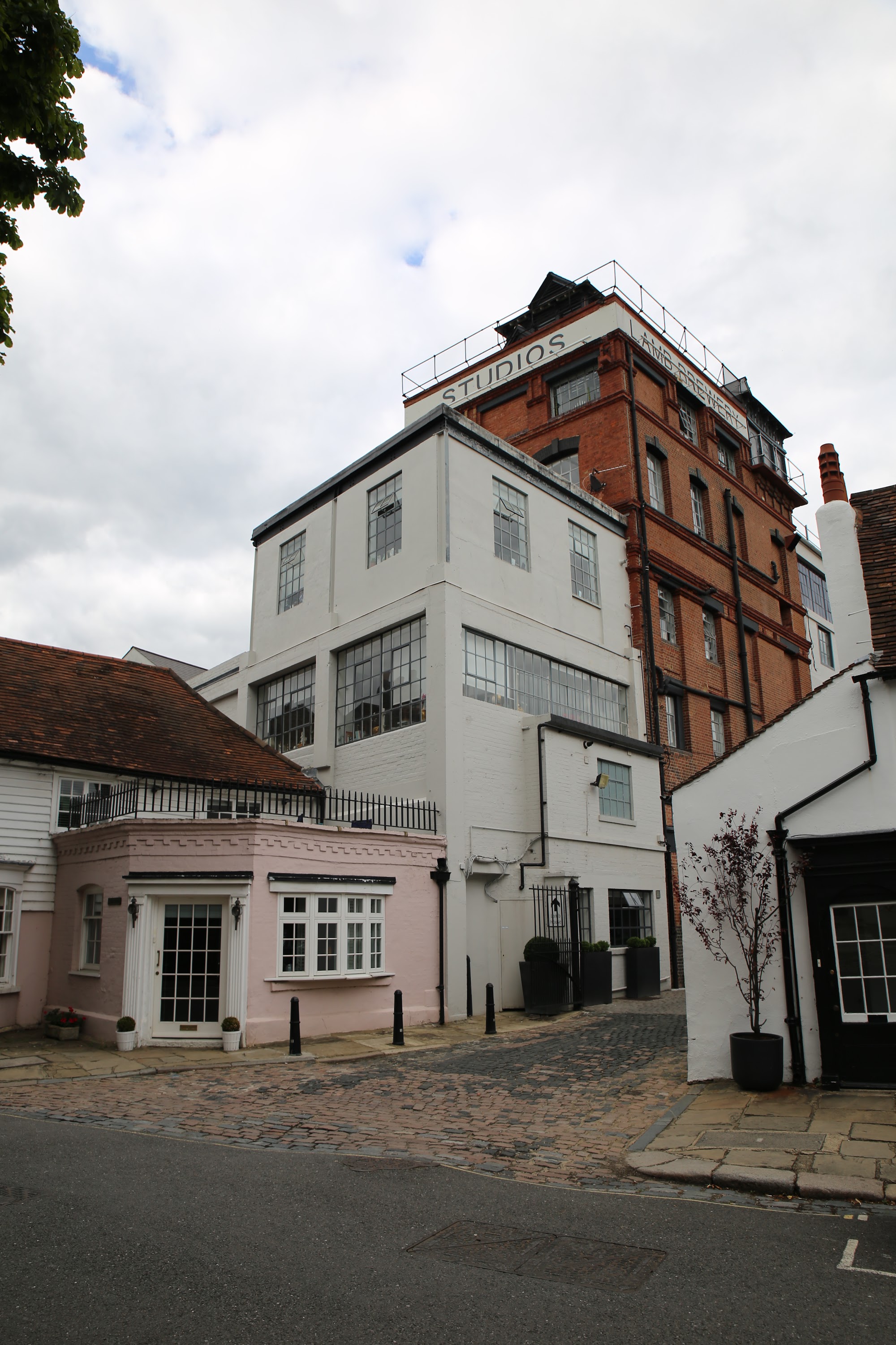 White and Red Brick Studios Building on Cobblestone Street