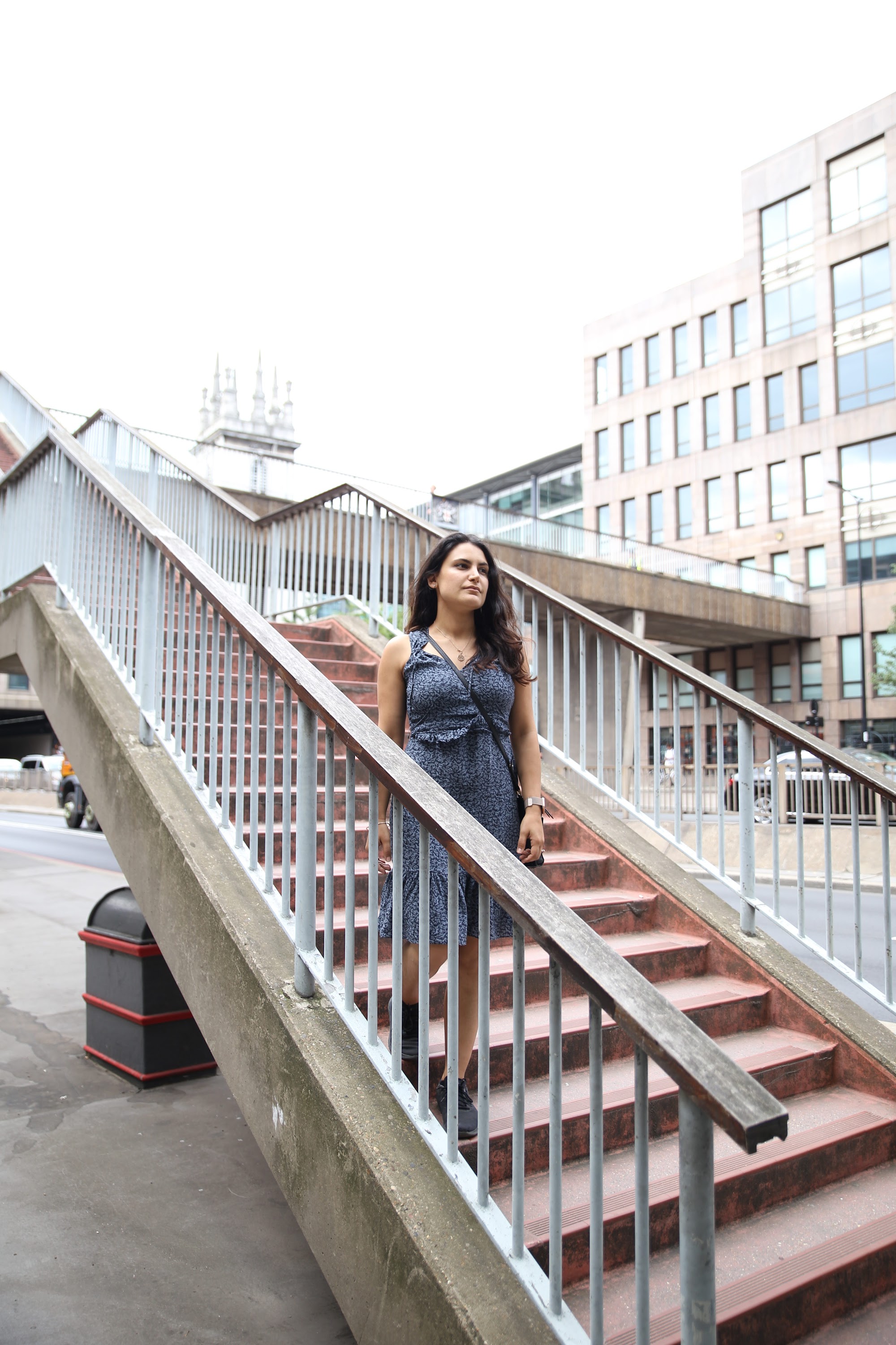 Woman Standing on Outdoor Staircase in Urban Setting