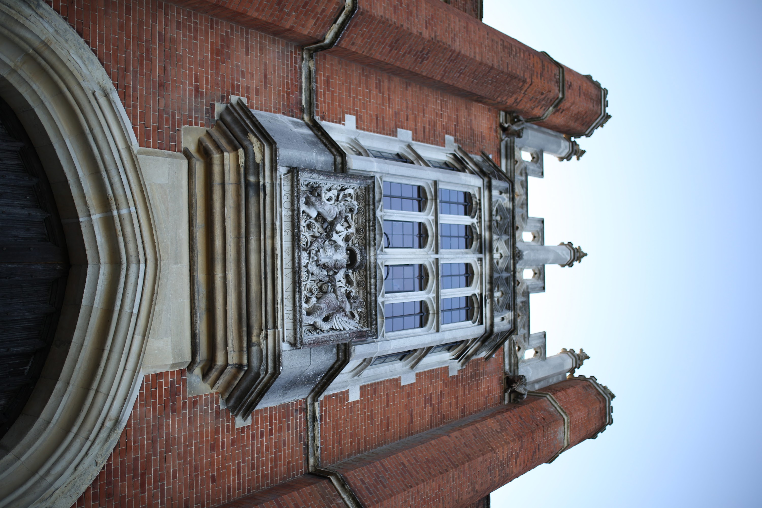 Ornate Stone Relief and Gothic Window on Red Brick Building