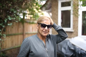 Woman in Sunglasses Adjusting Hair in Garden