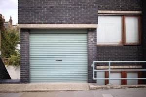 Green Roll-Up Garage Door on Dark Brick Building