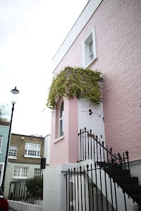 Pink Brick House with Greenery and Black Iron Stairs
