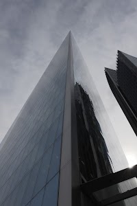 Tall Glass Skyscraper Against Cloudy Sky