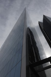 Modern Skyscraper Reflections Under Cloudy Sky
